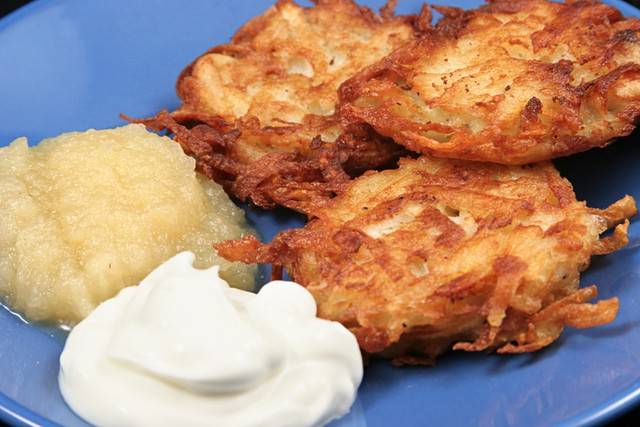 Latkes, with their traditional accompaniments: sour cream and applesauce